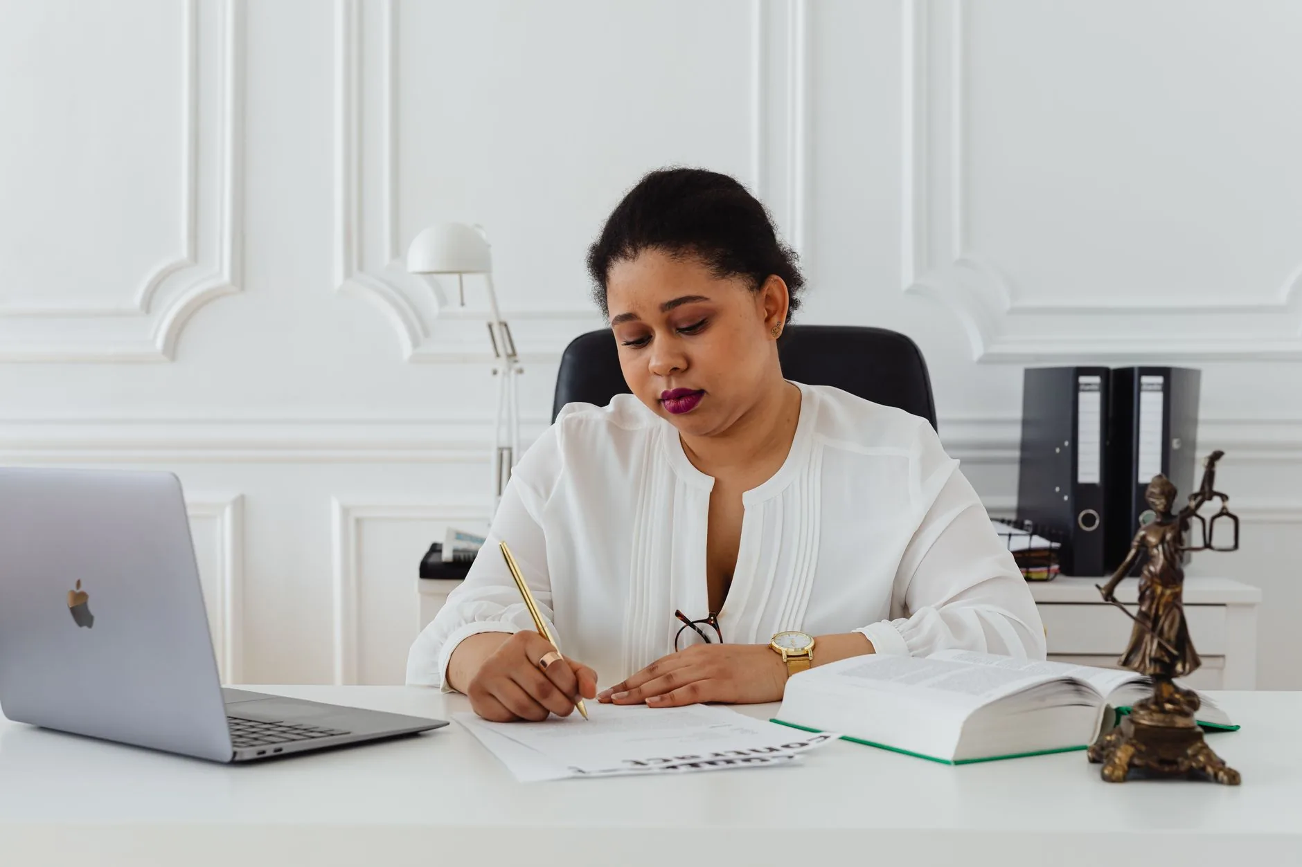 A client signing a document with a notary across a desk