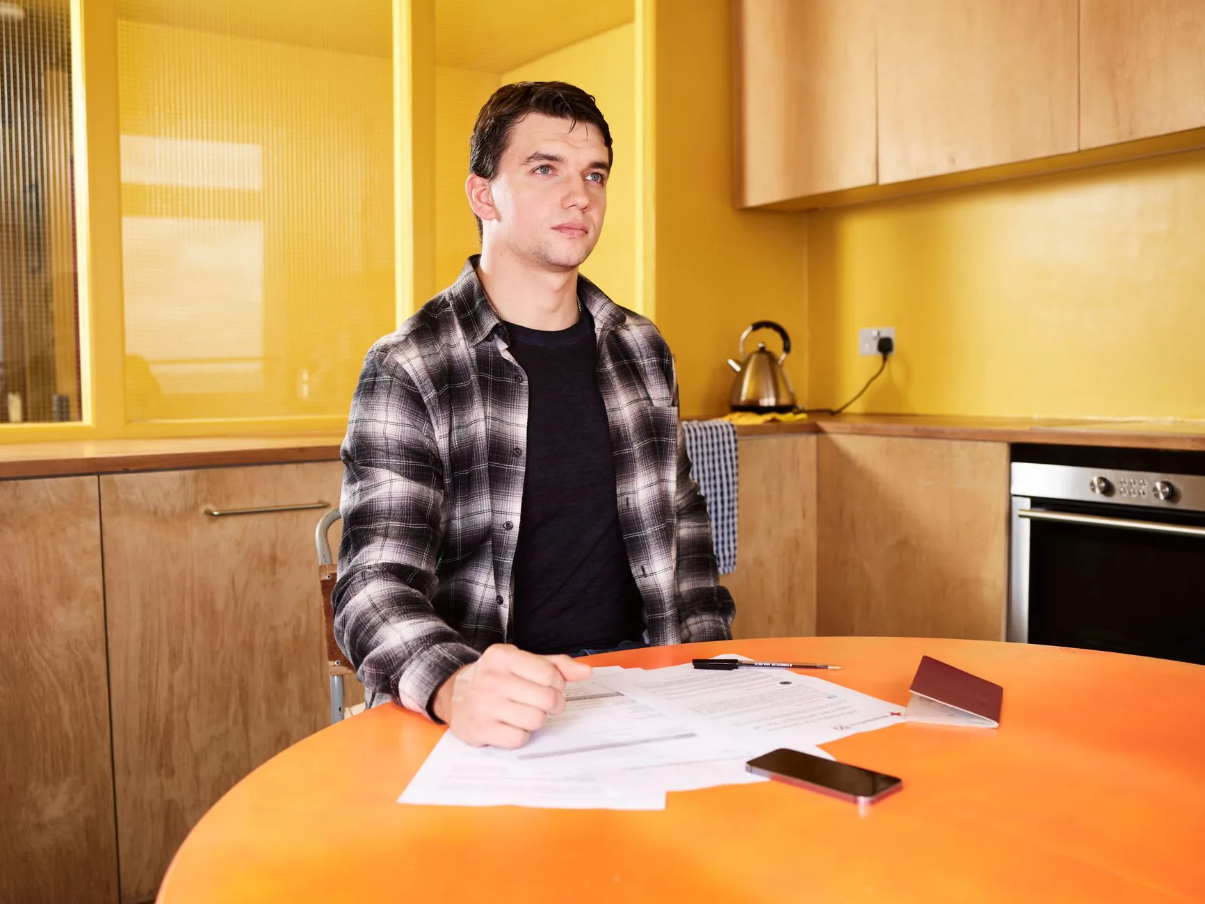 A tipped worker reviewing a pay stub and tax documents at home