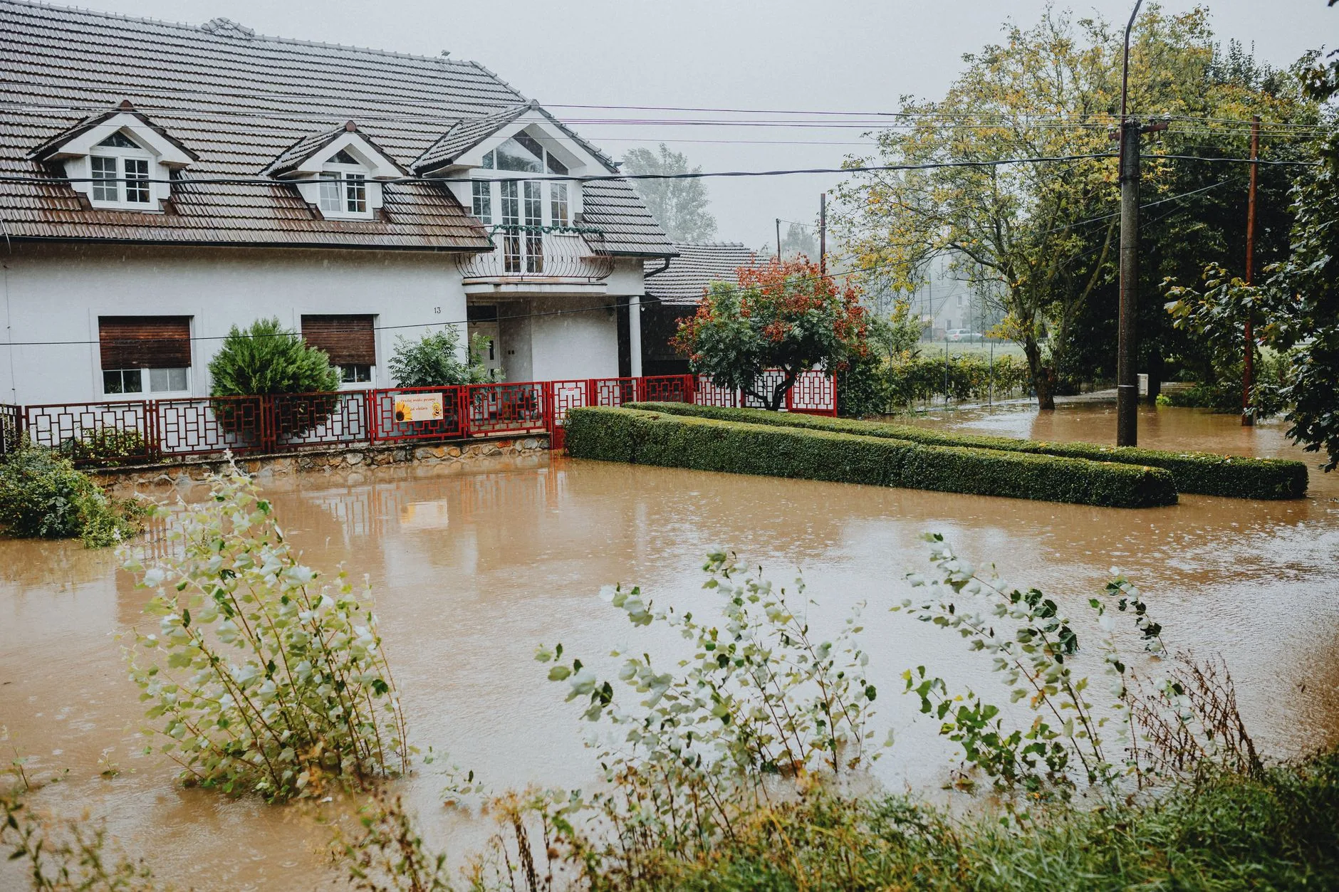 A flooded residential street with water surrounding homes after a storm