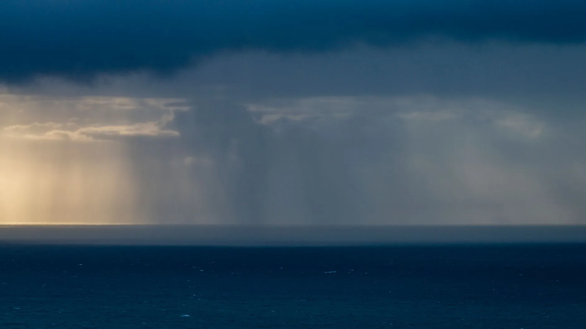 Dark storm clouds and heavy rain moving over a coastal neighborhood