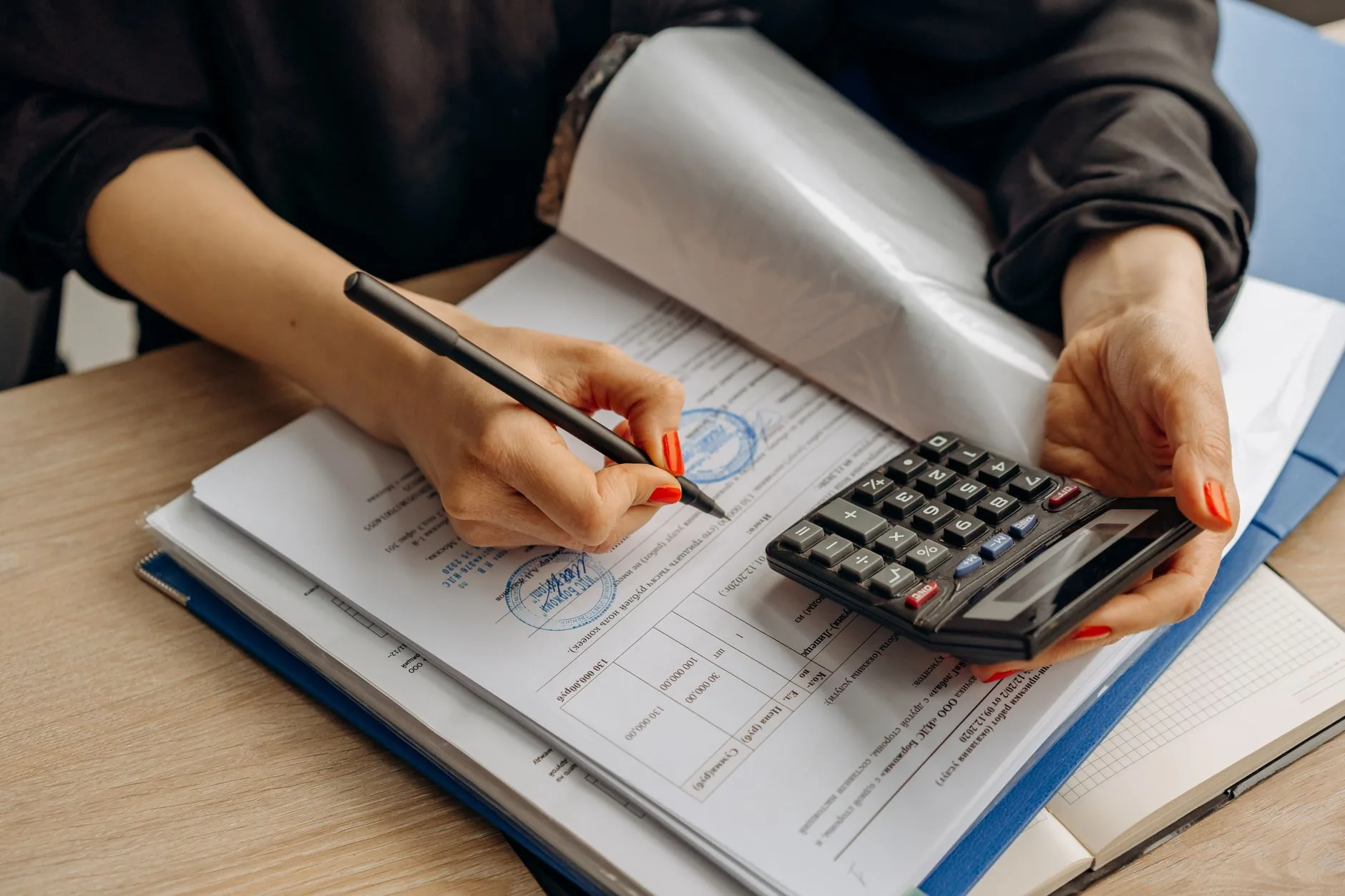 A tax preparer reviewing documents with a calculator