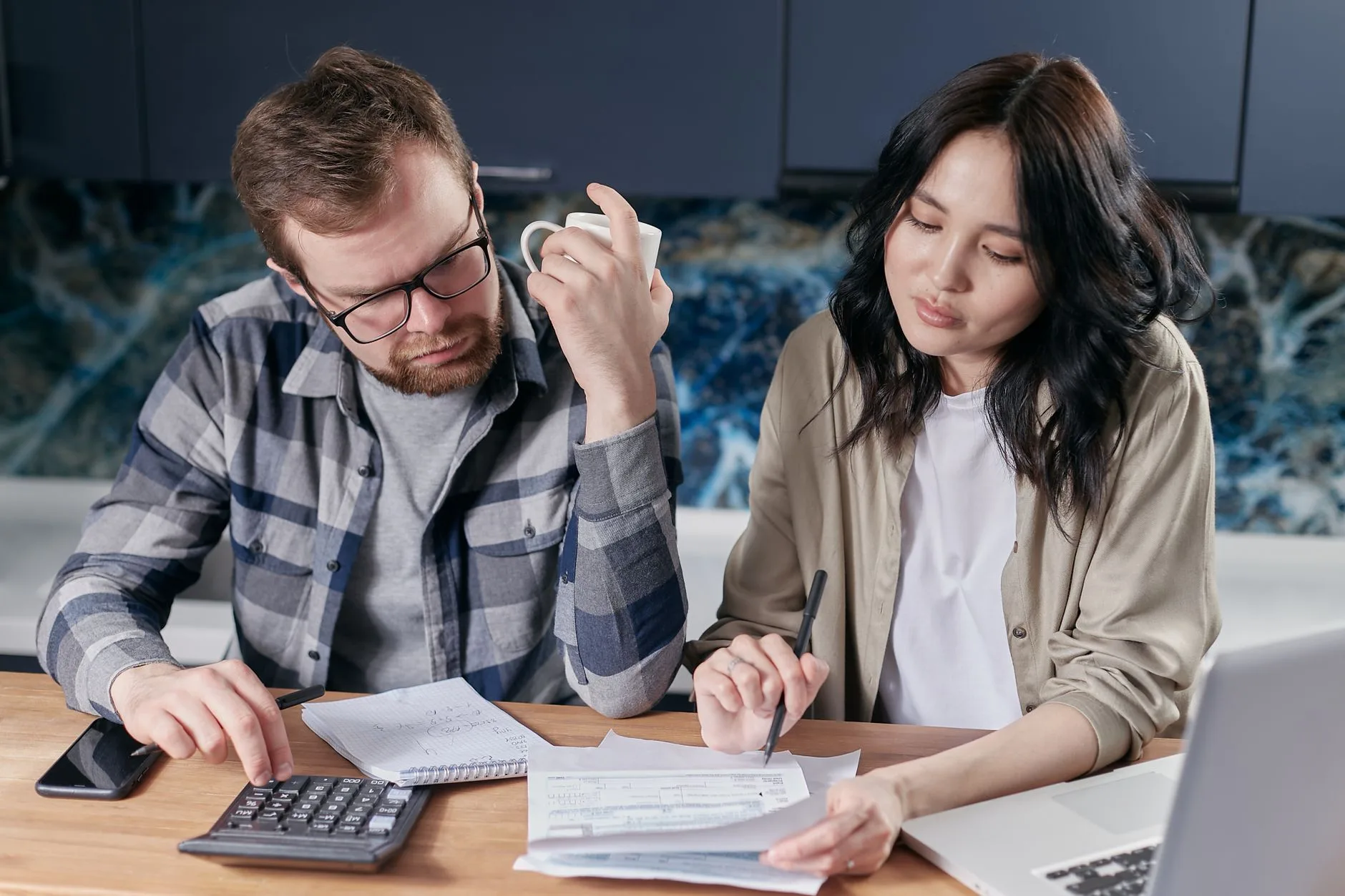 A health advisor sitting with a mother and daughter at home, reviewing coverage options